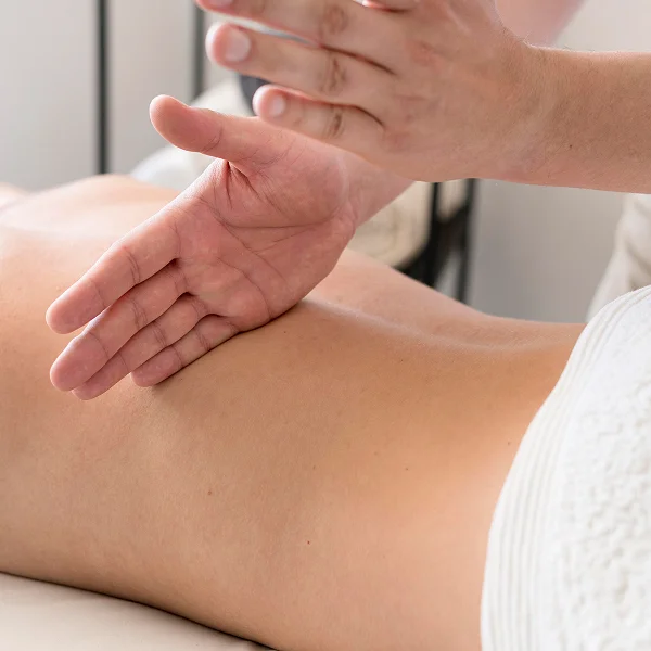 Une personne reçoit un massage du dos dans le cadre d'une séance de fasciathérapie.